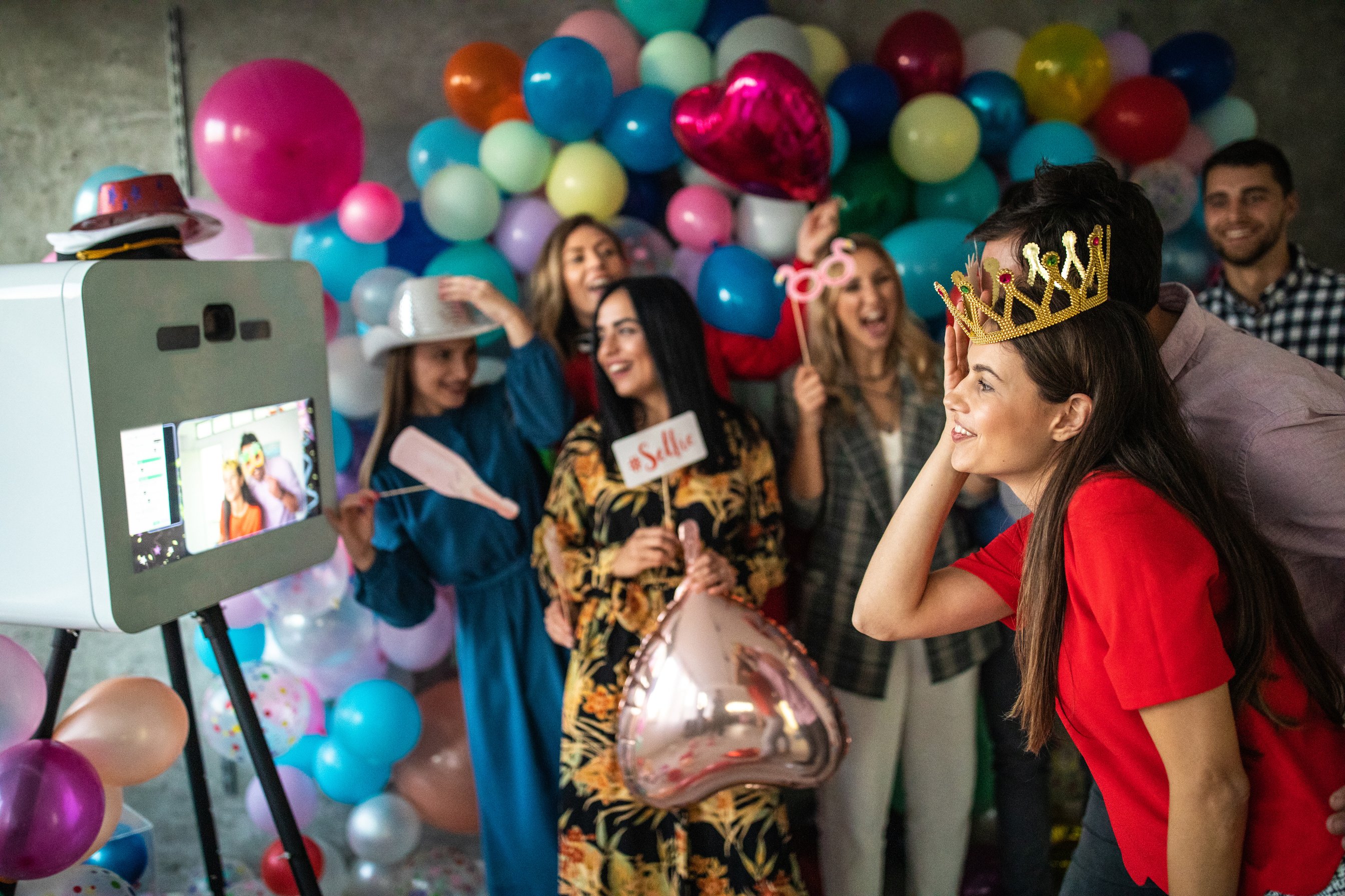 Young friends having fun at photo booth party